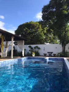 阿拉卡茹Village por do sol的一座位于庭院的游泳池,拥有白色的墙壁