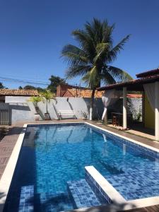 阿拉卡茹Village por do sol的一座棕榈树和房子的游泳池