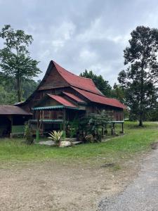 峇冬加里Kampung House (Minang) in Hulu Yam, Batang Kali的一座大型木制建筑,设有红色屋顶