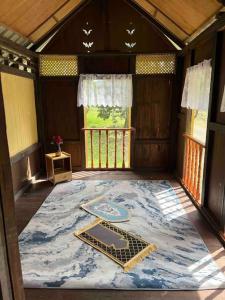 峇冬加里Kampung House (Minang) in Hulu Yam, Batang Kali的大房间,地板上有一个大地毯