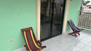 拉塞瓦Vacation Home La Ceiba的两把椅子坐在房子前门廊上