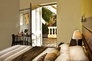 阿雷基帕卡萨代阿维拉住宿加早餐旅馆的一间卧室设有一张床,并有通往庭院的门