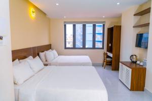 头顿Hai Duong Vung Tau Hotel - Khách sạn Hải Dương Vũng Tàu的酒店客房设有两张床和窗户。
