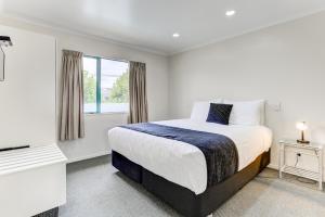 旺格努伊库克斯花园汽车旅馆 - 尔舒酒店的一间卧室设有一张大床和一个窗户。