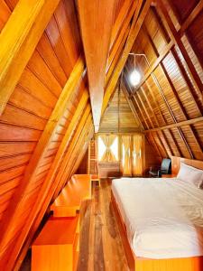 SinapuranANARA VILLA SAMOSIR MANAGED BY 3 SMART HOTEL的卧室配有木制天花板上的床铺