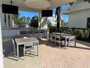 代托纳海滩Stylish Modern 3bd-2ba With Amenities的庭院设有2张桌子和椅子,酒吧