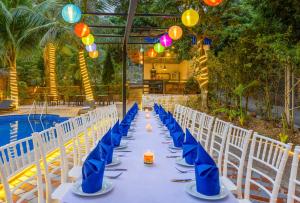 吉婆岛Tropical retreat Homestay的一张长桌,旁边是蓝色餐巾和椅子