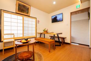 东京一戸建民泊 Tokyo St-ar House 東京星宿的客厅设有两张桌子和一扇窗户