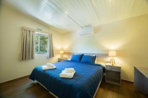 IndependenciaVista Alegre Natural Resort - Bungalows的一间卧室配有蓝色的床和2条毛巾