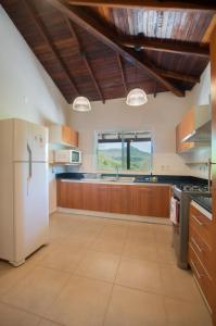 IndependenciaVista Alegre Natural Resort - Villas & Cabañas的厨房配有白色冰箱和木制橱柜。