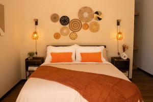 孔塔多拉Avani的卧室配有一张带橙色枕头和盘子的床铺。