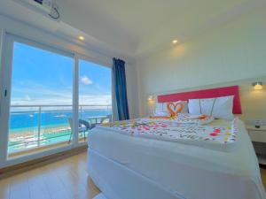 马富施iCom Marina Sea View的一间卧室设有一张大床,享有海景