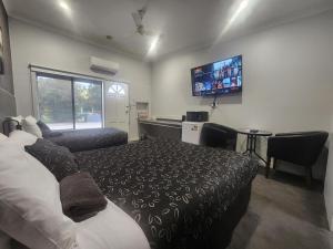 瑟尔24Seven汽车旅馆及公寓的一间卧室配有一张床和一台平面电视