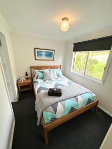 雅纳基Tidal Dreaming Seaview Cottages的一间卧室设有一张大床和窗户