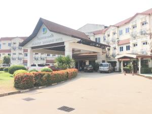 万象Dansavanh Vientiane Hotel的停车场内有车辆的建筑物