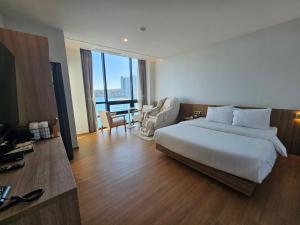 蔚山The Van Hotel的酒店客房设有一张大床和一张书桌。