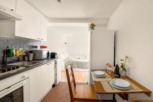 阿格诺Apartment View And Pool - Happy Rentals的厨房配有桌子和冰箱