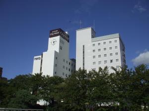 鸟取市鸟取市酒店的一座白色的大建筑,上面有时钟