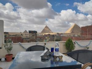 开罗Eagles Pyramids View的一张带眼镜的桌子,享有金字塔的景色