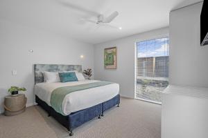 帕帕莫阿Tasman Holiday Parks - Papamoa Beach的一间卧室设有一张大床和一个窗户。