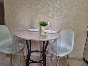 乌斯季卡缅诺戈尔斯克Аппартаменты 2 / х комнатная的酒杯桌子和盆栽植物