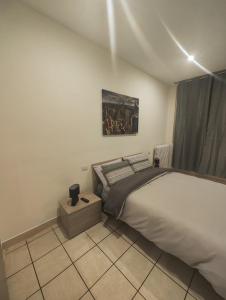 诺瓦拉Appartamento c&y Monte san Gabriele的卧室配有一张床,墙上挂有绘画作品