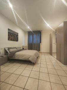 诺瓦拉Appartamento c&y Monte san Gabriele的卧室配有1张床,铺有瓷砖地板。