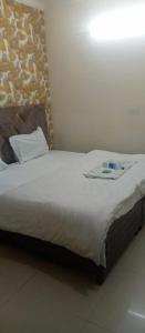 钱德加尔Hotel king palace的一间卧室配有一张带白色毯子的大床