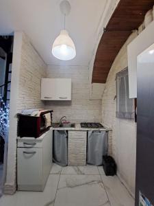 维勒塔巴雷亚Carmela e Gennaro casa vacanze的厨房配有水槽和炉灶 顶部烤箱