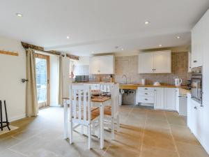 Bradwell1 Bed in Hathersage 78016的厨房配有白色橱柜和桌椅