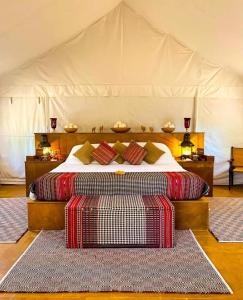 斋沙默尔Luxury The Sunrise Resort with swimming pool Jaisalmer的卧室内带2个地毯的帐篷内的一张床位