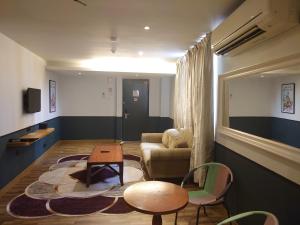 吉隆坡Katel Kuala Lumpur formally known as K Hotel的客厅配有沙发和桌椅