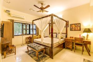 大诺伊达House Of Comfort Greater Noida的一间卧室配有一张天蓬床和一张书桌