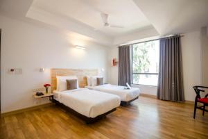 新德里Townhouse 013 New Friends Colony的酒店客房设有两张床和窗户。