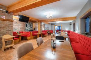 泽尔内什蒂Resort 7 Crai - Cabana Craiul Crailor的一间设有长桌和红色座椅的餐厅