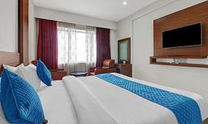 特里凡得琅FabHotel Majestic South Gate的酒店客房设有一张大床和一台电视。