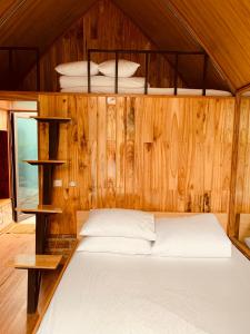 Yên BáiHomestay Suối Khoáng Minh Hằng的卧室配有木墙内的一张床