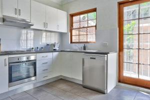 悉尼Elegant House Chippendale - City Center 2 E-Bikes Included的厨房配有白色橱柜和洗碗机。