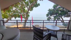 布桑加Alam Indah Busuanga Beach and Villas的阳台配有桌椅,享有海景。