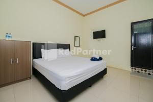 PaciranGrand Kencana Guesthouse near Wisata Bahari Lamongan Mitra RedDoorz的一间卧室配有一张床和一台电视。
