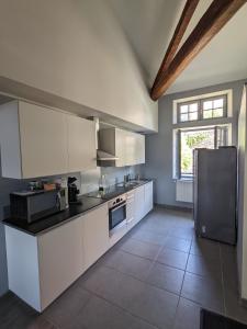 勒布伊Superbe appartement duplex en hyper centre的厨房配有白色橱柜和冰箱。