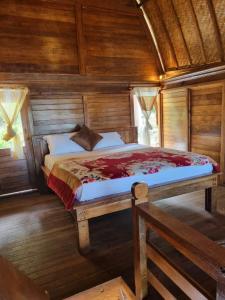 金塔马尼巴鲁娜别墅酒店的木制客房内的一间卧室,配有一张床