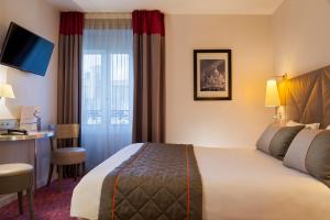 巴黎提姆玛德莱娜剧院酒店的酒店客房配有一张床铺、一张桌子和一张书桌。