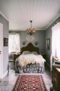 克里斯蒂娜港Åkerbo gård charmigt renoverad flygel的壁纸客房内的一间卧室配有一张床