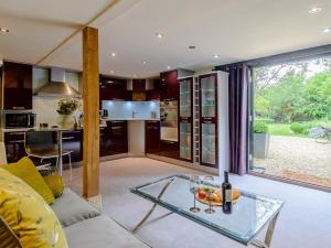 Ludgershall1 Bed in Bicester Village CLEAR的厨房以及带玻璃桌的起居室。