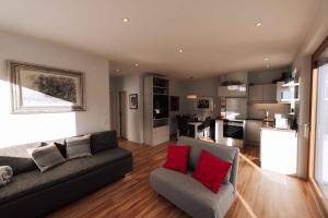 盖布利茨Nina´s Home的客厅配有灰色沙发和红色枕头
