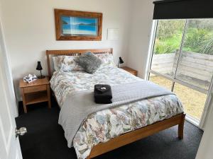 雅纳基Tidal Dreaming Seaview Cottages的一间卧室设有一张床和一个窗口