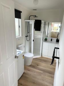 雅纳基Tidal Dreaming Seaview Cottages的白色的浴室设有卫生间和淋浴。
