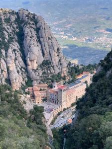 科尔百托Casa acogedora al pie de Montserrat的悬崖边的山上的建筑