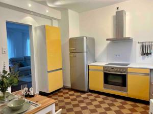 罗伊特林根Gemütliche Altbauwohnung in RT-Betzingen的厨房配有不锈钢冰箱和桌子